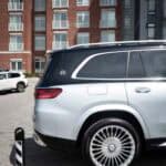 Silver luxury SUV parked outside modern apartment building