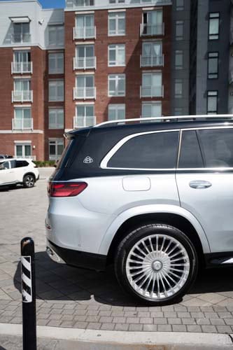 Silver luxury SUV parked outside modern apartment building