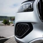 Close-up of white car headlight and front grille