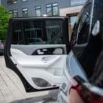 Open rear car door in urban parking area