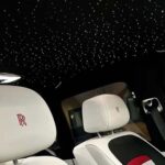 Luxury car interior with starlit ceiling and white seats