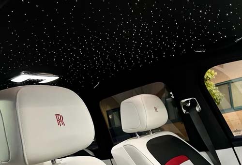 Luxury car interior with starlit ceiling and white seats