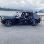 Black luxury SUV with open doors by waterfront
