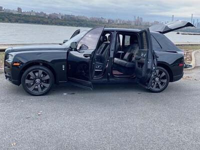 Black luxury SUV with open doors by waterfront