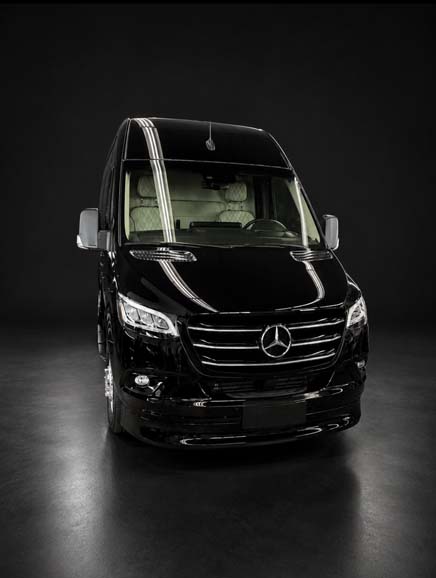 Sleek black Mercedes-Benz Sprinter van on dark background.