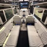 Luxurious interior of a custom van with white leather seating.