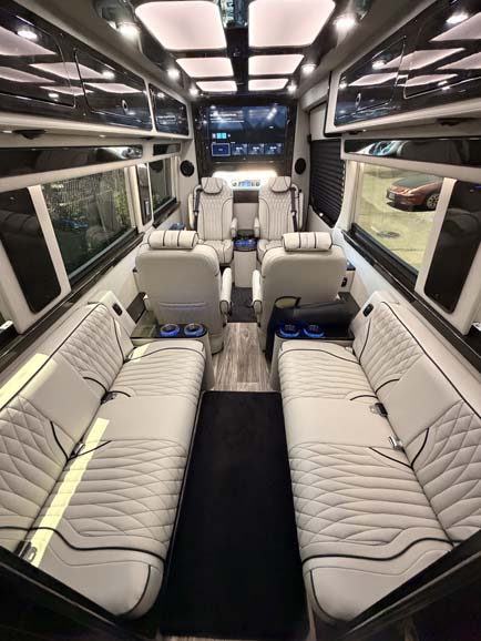 Luxurious interior of a custom van with white leather seating.