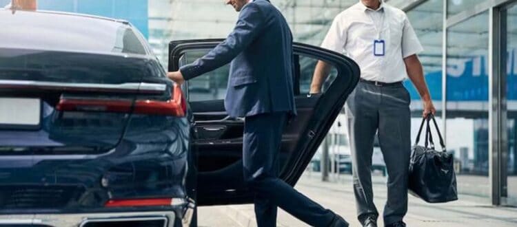 Businessman exiting luxury car at airport curbside