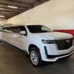 White stretch Cadillac Escalade limousine in garage