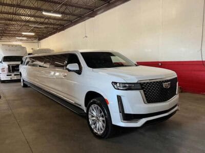 White stretch Cadillac Escalade limousine in garage