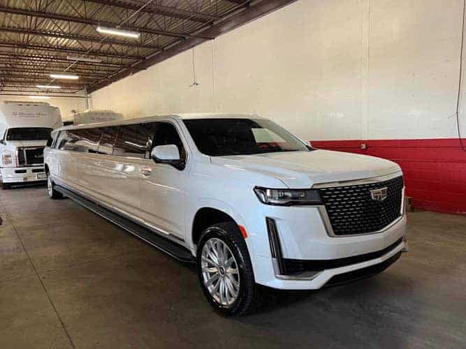 White stretch Cadillac Escalade limousine in garage