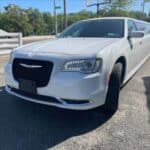 White stretch limousine parked on sunny street