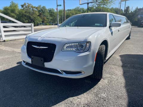 White stretch limousine parked on sunny street