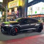 Matte black Lamborghini Urus in Times Square at night
