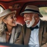 Smiling elderly couple in vintage car