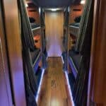 Narrow sleeper bus corridor with bunk beds