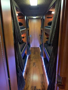 Narrow sleeper bus corridor with bunk beds
