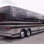 Black luxury tour bus parked outside building