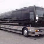 Black luxury tour bus parked on pavement
