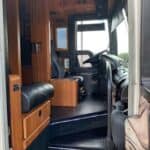 RV interior with wooden cabinets and driver's seat