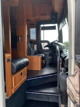 RV interior with wooden cabinets and driver's seat