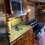RV kitchen interior with sink, microwave, sofa.
