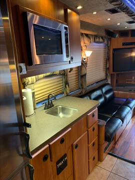 RV kitchen interior with sink, microwave, sofa.
