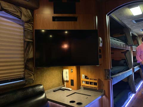Tour bus interior with TV and bunk beds