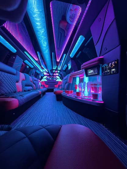 Neon-lit luxury limousine interior with bar and leather seating