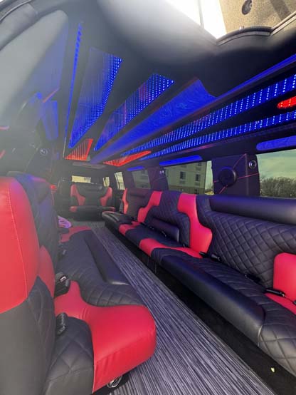 Luxury limousine interior with red-black leather seats and blue LEDs