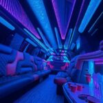 Neon-lit luxury limousine interior with seating and red cups