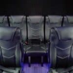 Black leather theater seats with blue floor lighting