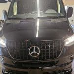 Front view of black Mercedes-Benz Sprinter van indoors