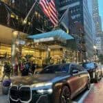 BMW sedan parked outside The Westin with American flags