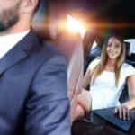 Woman using laptop in backseat of chauffeured car