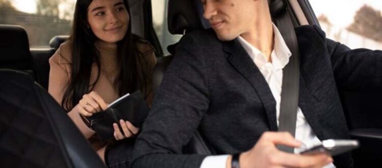 Man driving car glancing at woman holding wallet