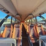 Empty coach bus interior with brown leather seats