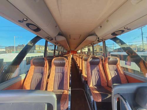 Empty coach bus interior with brown leather seats