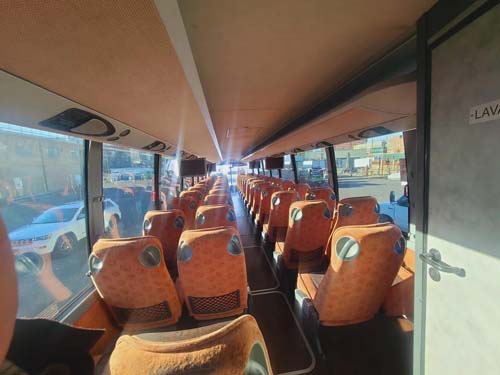 Interior of bus with rows of orange seats