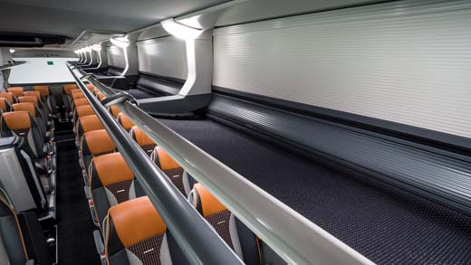 Modern train interior with orange seats and luggage racks