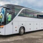 White coach bus parked on roadside
