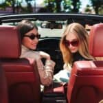 Two women in convertible with red interior