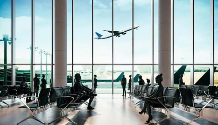 Passengers waiting in airport terminal with plane taking off