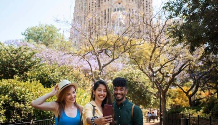 Three friends taking selfie in sunny city park