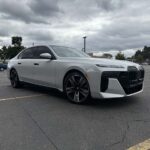 Silver BMW luxury sedan parked under cloudy sky