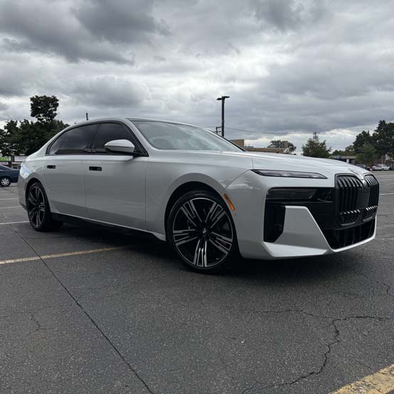 Silver BMW luxury sedan parked under cloudy sky