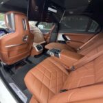 Luxury car rear cabin with brown leather seats and screens