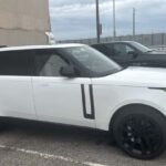 White Range Rover parked beside a building