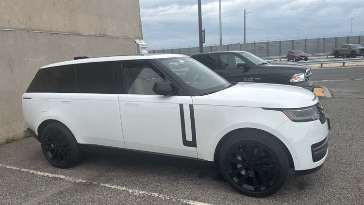 White Range Rover parked beside a building