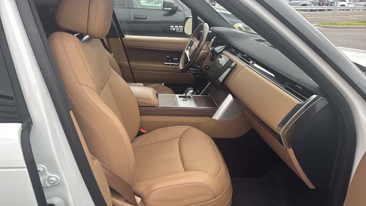 Tan leather front seats and dashboard inside luxury SUV